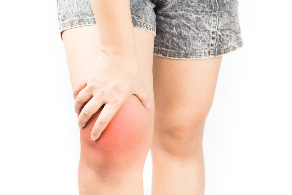 Female holding swollen inflamed right knee wondering what to do when you find a lump in your knee